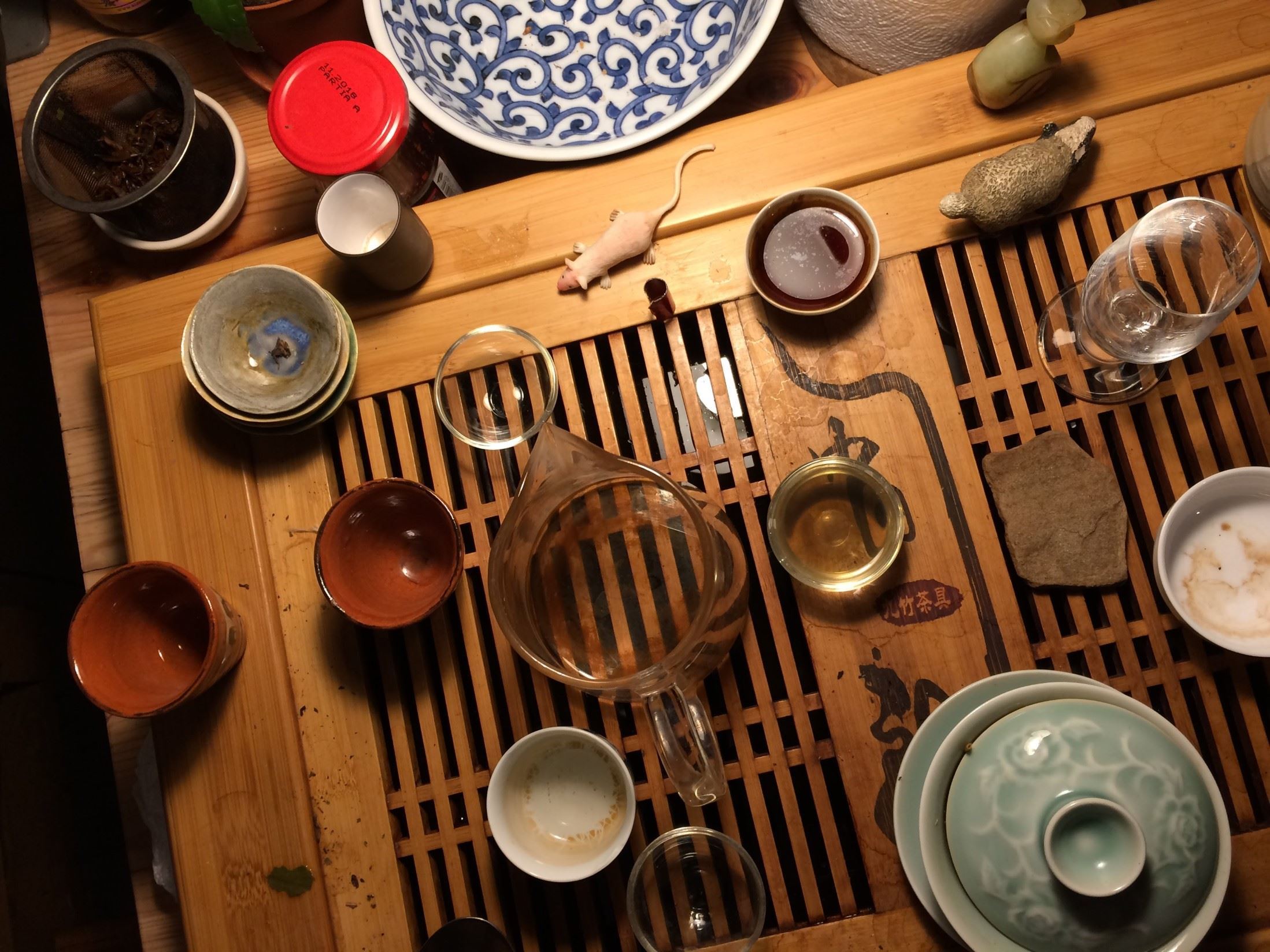 Drewniany stół zastawiony czarkami i dzbankiem do ceremonii parzenia herbaty.